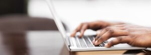 Person Typing on Laptop Keyboard