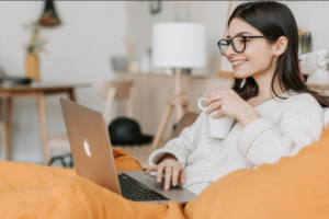 Woman drinking coffee on computer - enlarged