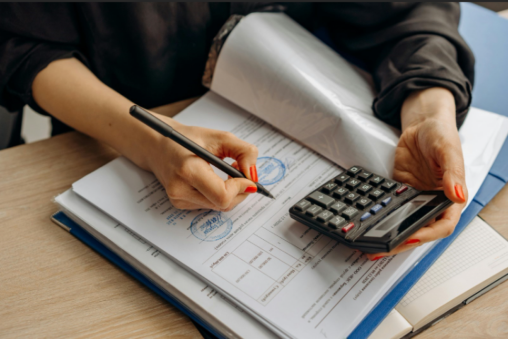 Worker using calculator and writing results.