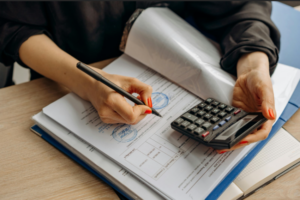 Man using a calculator and writing results.