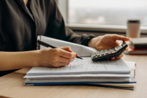 Worker using a calculator and writing results.