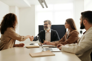 Team members shake hands during a work meeting.