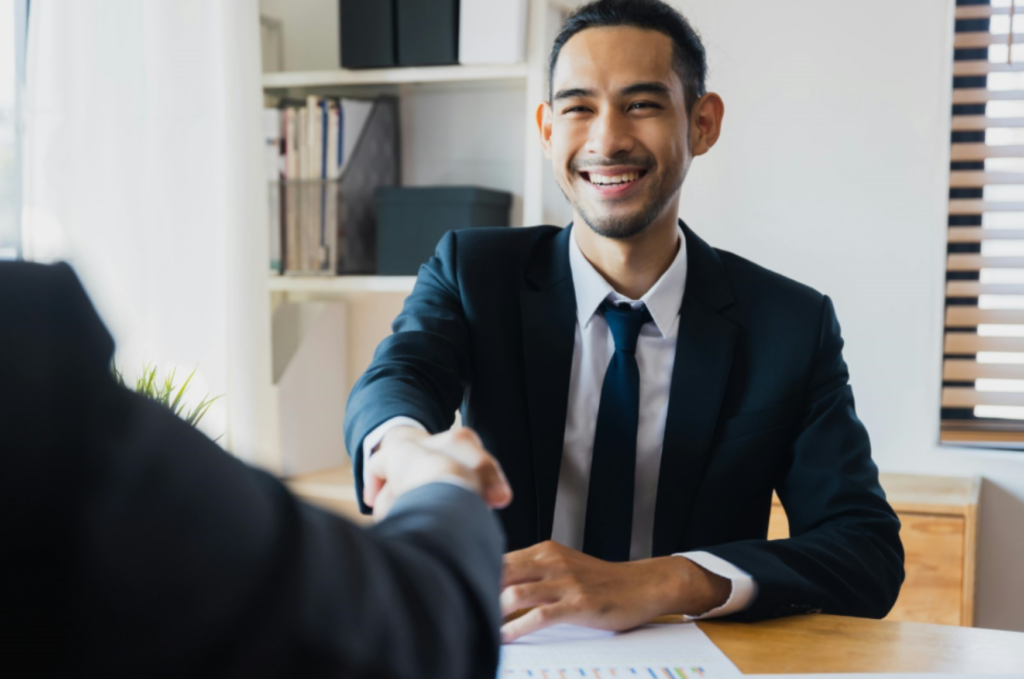 Man in suit shaking another mans hand enlarged.