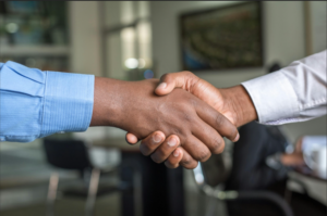 Two workers shaking hands up close.