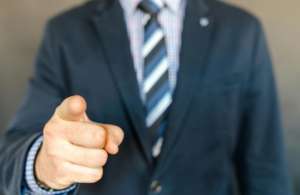 Man in suit pointing at the screen.