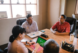 Coworkers sitting around a table participating in a meeting.