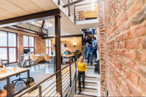 Team of workers walking down stairs heading into an open office.