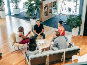 Five people sitting around a table having a discussion.