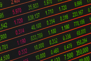Up close picture of a screen showing changing numbers of many stocks.