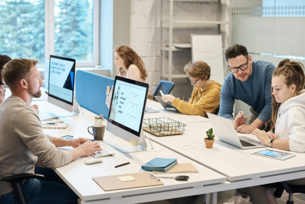 Coworkers working in a office with computers. - Enlarged